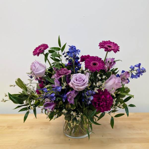 Mixed purple bouquet in a clear glass vase