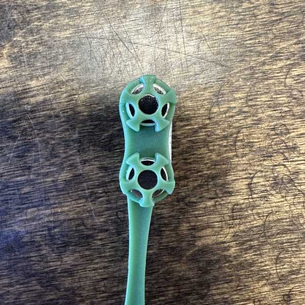 A small teal plastic floral pick on a wooden surface
