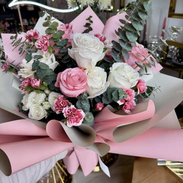 Pink and white rose bouquet with carnations and eucalyptus wrapping