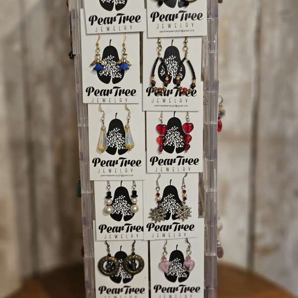 Display rack of assorted dangling earrings on PearTree Jewelry cards