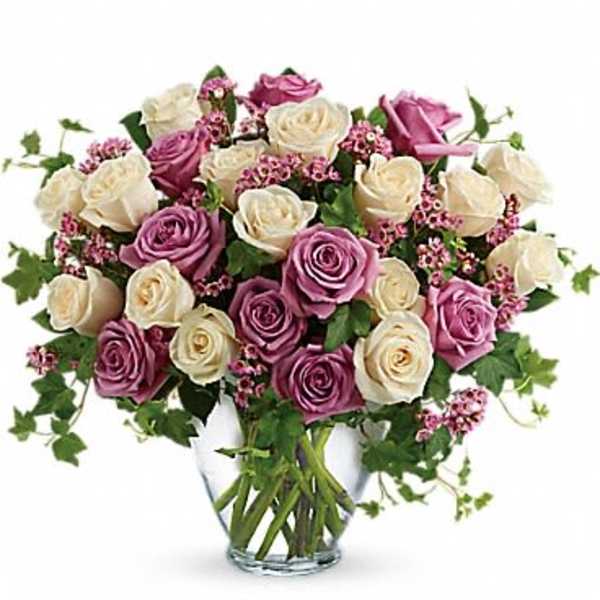 Pink and white roses arranged in a clear glass vase
