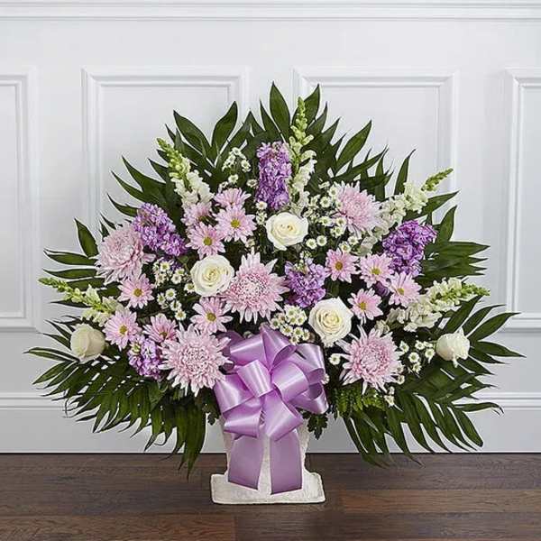Standing floral spray with pink and white flowers and a purple ribbon bow