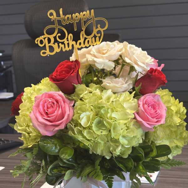 Birthday flower arrangement with roses and hydrangeas in a glass vase