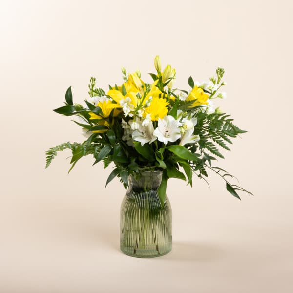 Yellow and white mixed bouquet in a ribbed glass vase