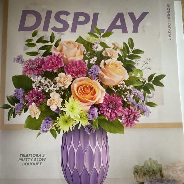 Bouquet of peach roses, purple mums, and lavender filler in a purple vase