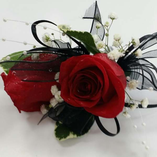 Red rose corsage with black ribbon and white baby's breath