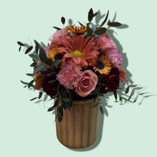Mixed bouquet in a gold vase with pink and orange flowers