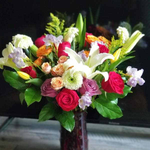 Mixed bouquet of roses and lilies in a glass vase