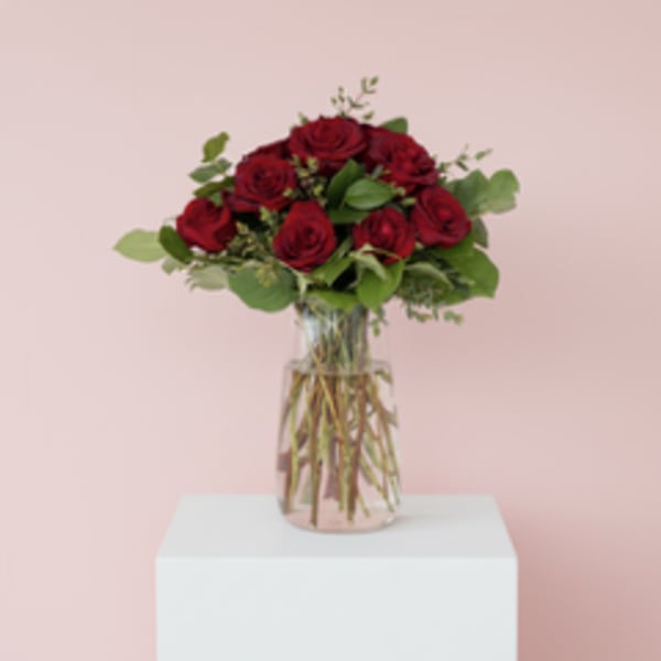 Red roses arranged in a clear glass vase