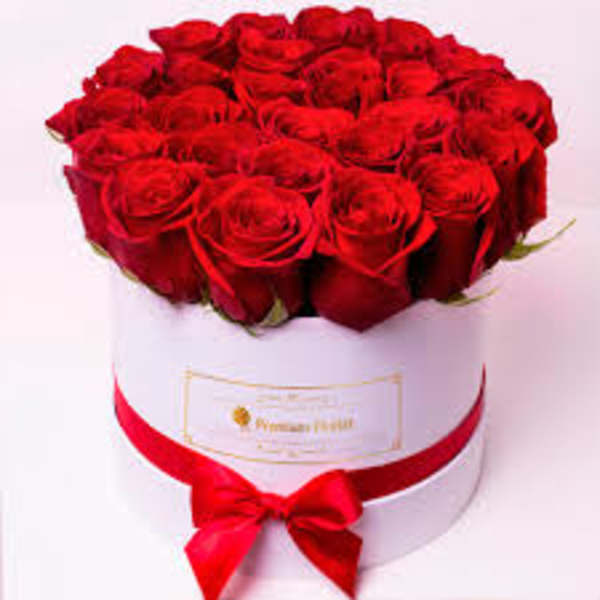 Round box of red roses with a red ribbon bow