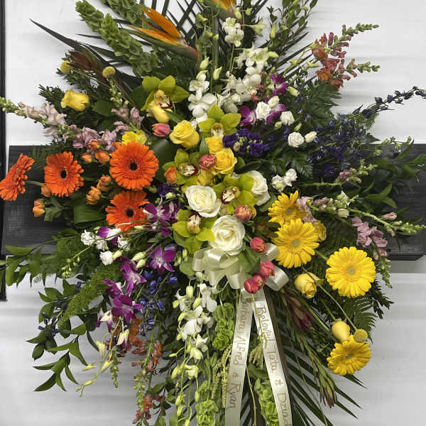 Large mixed floral spray with bright gerberas, roses, and orchids