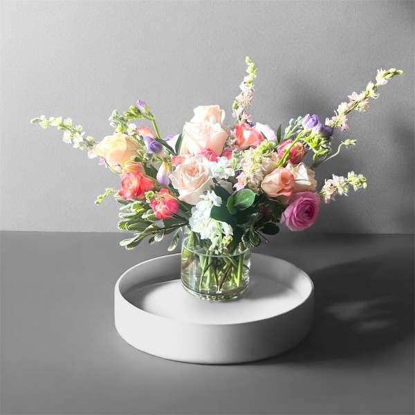 Mixed pastel flower arrangement in a clear glass vase