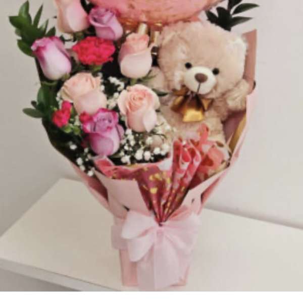 Pink rose bouquet with a teddy bear and ribbon wrap