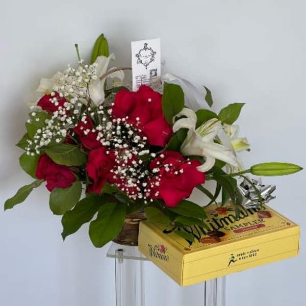 Bouquet of red roses and white lilies with a yellow gift box