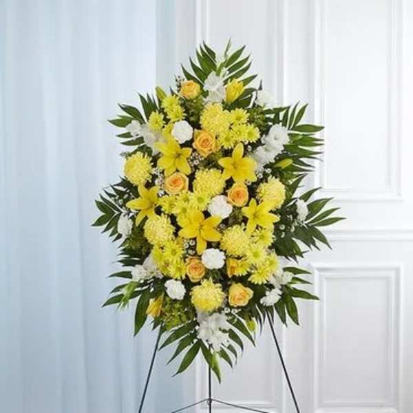 Standing floral spray with yellow and white flowers on an easel
