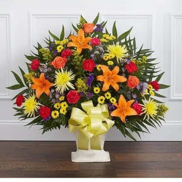 Standing floral spray with orange lilies and mixed bright blooms