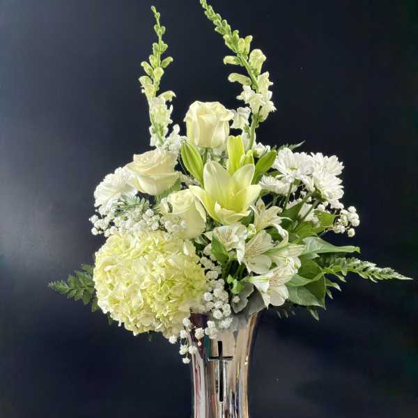 White floral arrangement in a tall silver vase