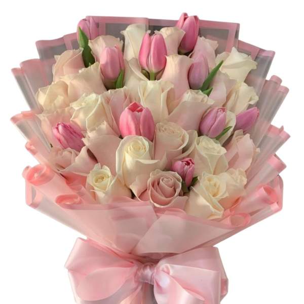 Pink tulips and pale roses wrapped in pink paper with a satin bow