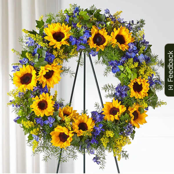 Sunflower wreath with blue flowers on a black stand