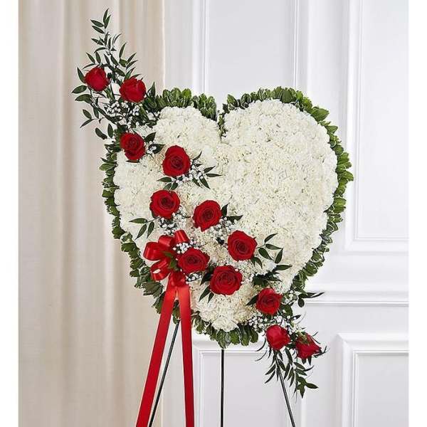 Heart-shaped floral spray with white blooms and red roses on a stand