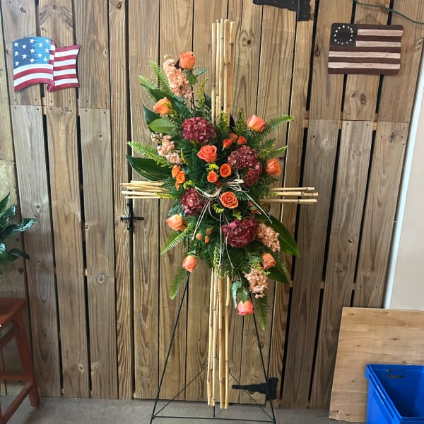 Tall floral standing spray with orange roses and burgundy hydrangeas on a bamboo easel