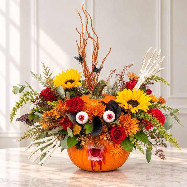 Halloween pumpkin arrangement with sunflowers, roses, and skeleton hands