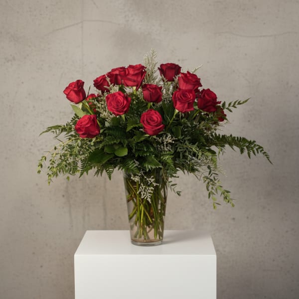 Red roses arranged in a clear glass vase