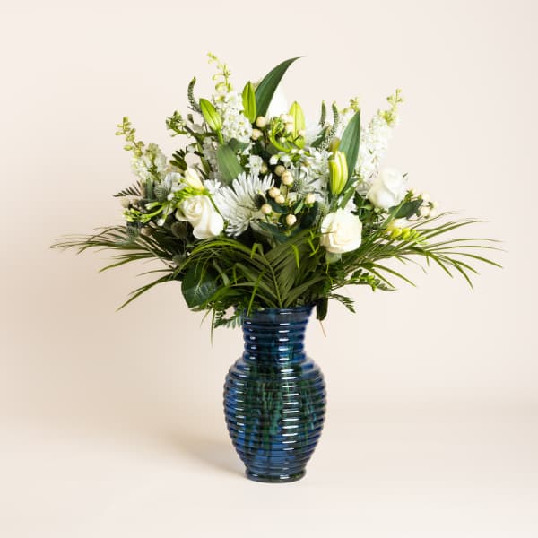 White floral arrangement in a blue glass vase
