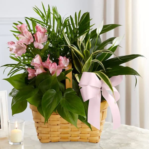 Pink flowers in a woven basket with a pink ribbon