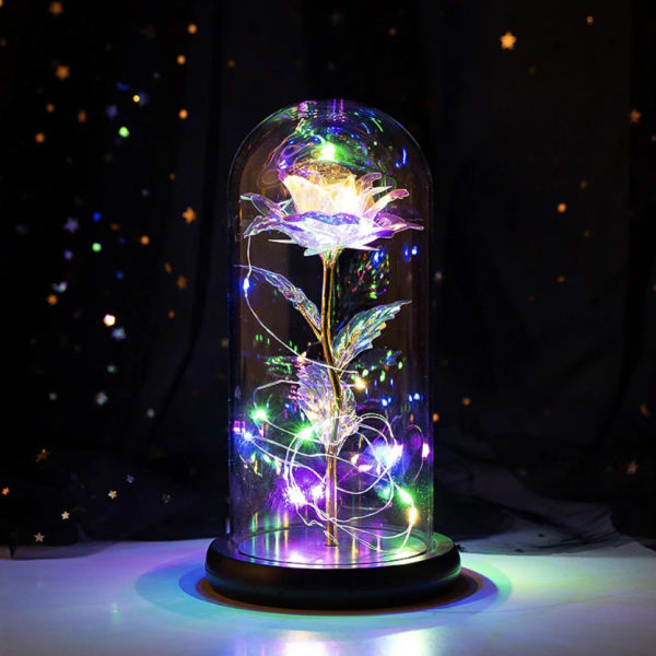 Glowing artificial flower under a glass dome with multicolor lights