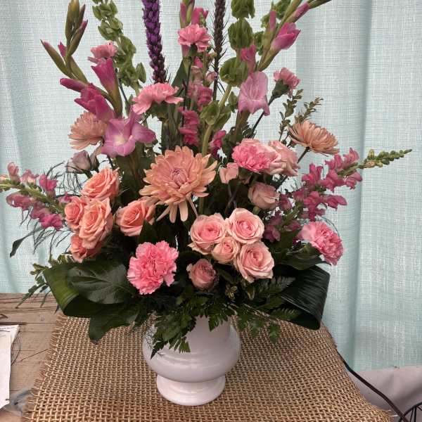 Pink and peach floral arrangement in a white vase