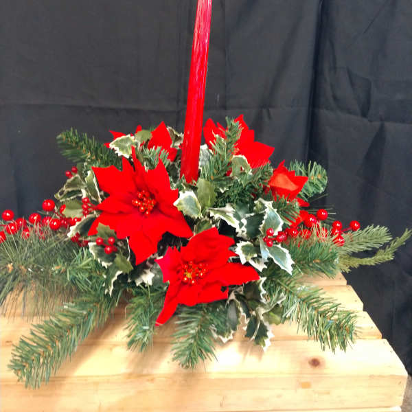 Holiday centerpiece with red poinsettias and evergreen branches