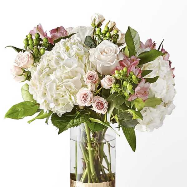 White and blush bouquet in a clear glass vase