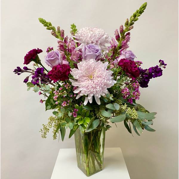 Purple and pink mixed bouquet in a clear glass vase