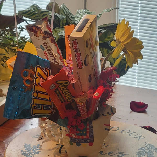 Candy bouquet with assorted chocolate bars and a yellow daisy