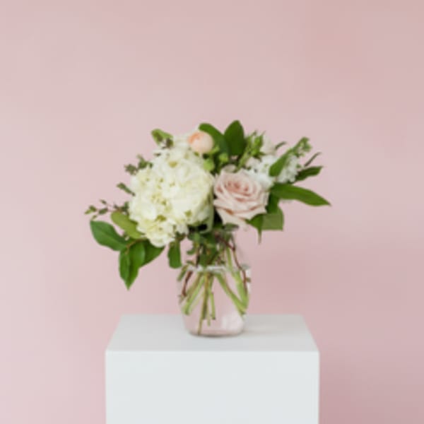 Bouquet of white hydrangea and pale pink roses in a glass vase