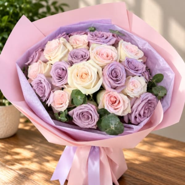 Bouquet of pink and lavender roses wrapped in pastel paper