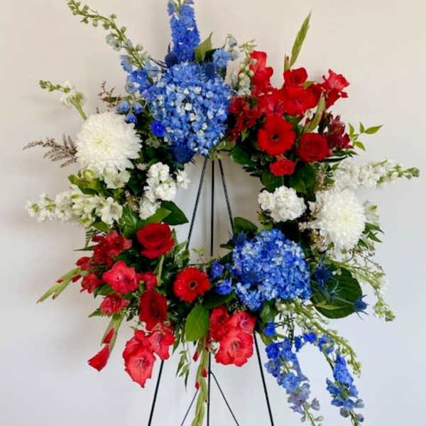 Red, white, and blue floral wreath on a black easel