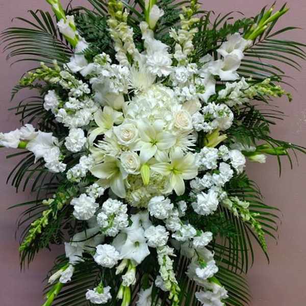 Large white funeral spray with lilies and roses