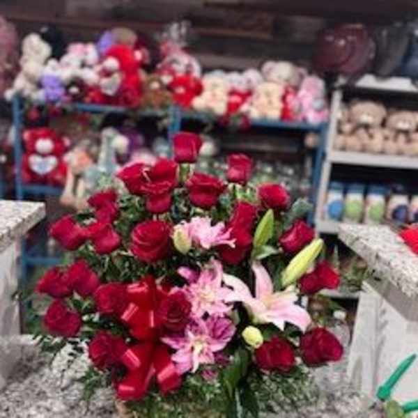 Bouquet of red roses and pink lilies with a red ribbon
