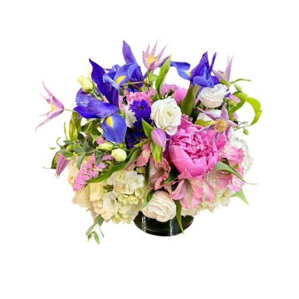 Mixed bouquet of purple, pink, and white flowers in a black vase