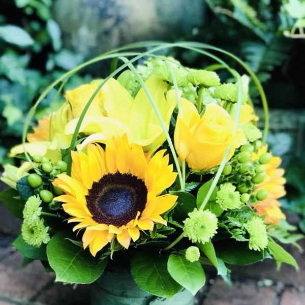 Yellow sunflower and rose arrangement in a green vase
