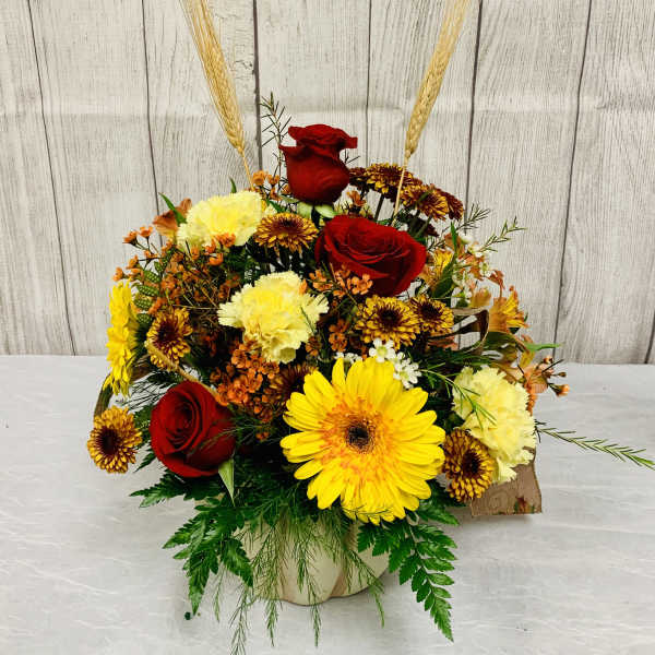 Mixed bouquet with red roses, yellow gerbera daisies, and carnations in a vase