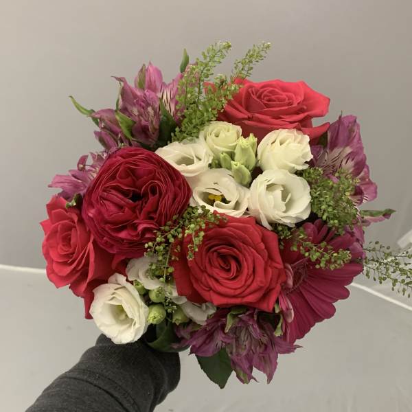 Handheld bouquet of red and white roses with purple flowers
