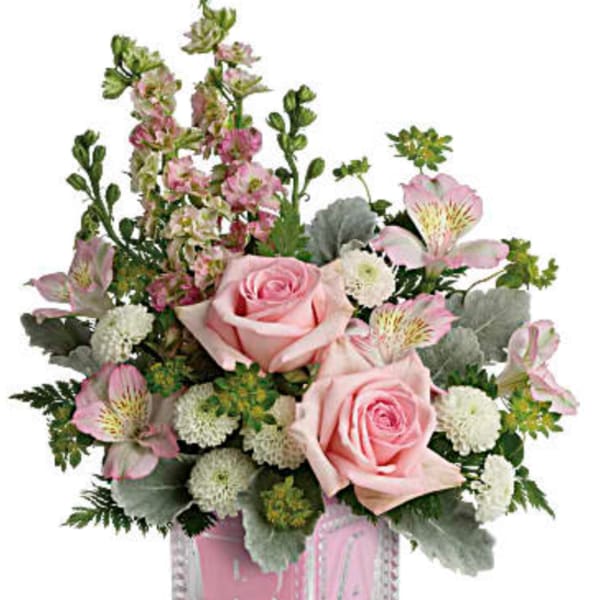 Pink roses and mixed flowers in a clear glass cube vase