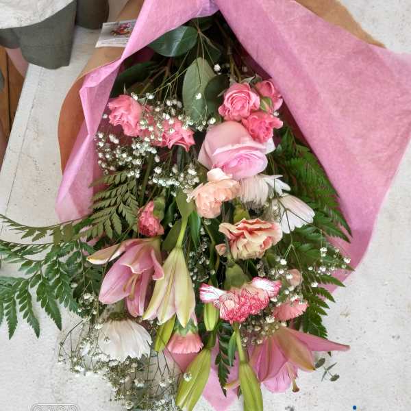 Pink mixed bouquet with roses, lilies, and carnations wrapped in pink paper
