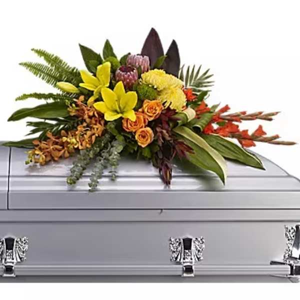 Colorful floral spray arranged on a silver casket