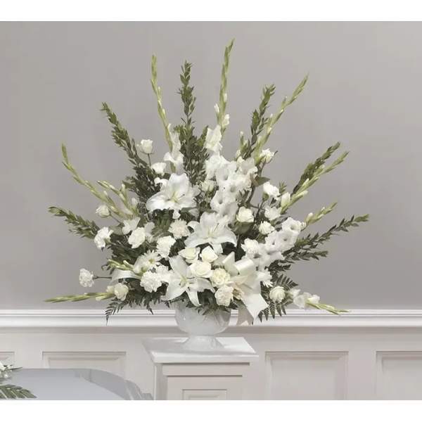 White floral arrangement in a clear pedestal vase