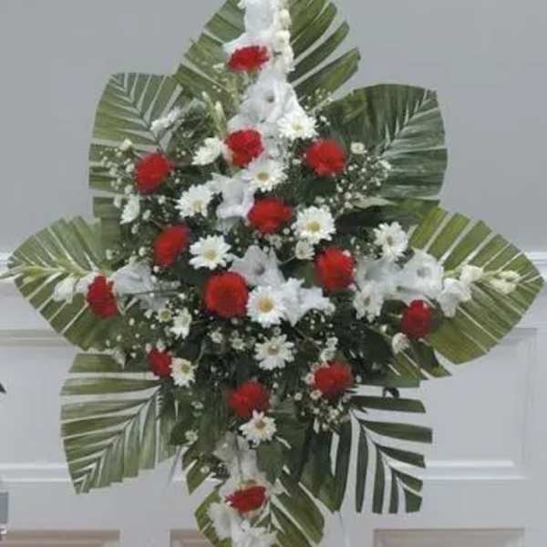 Standing floral spray with red and white flowers and large palm leaves