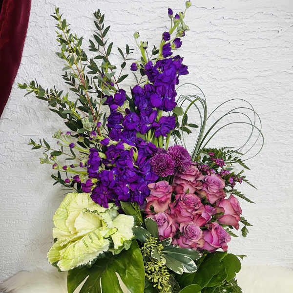 Purple and pink floral arrangement in a clear glass vase